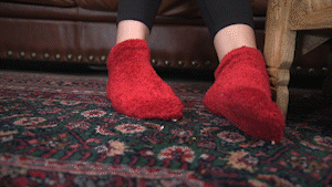 Jolene Hexx walks in to crash her step-brother's slumber party. However, she doesn’t know that as a prank, he and his friends decided to shrink themselves in the carpet. Jolene walks in, completely unaware as she steps on a few of his friends. After a bit, she notices his little shrinking device on the floor and realizes he and his friends shrunk themselves. Amused, she stomps around looking for them. As she sits on the couch, she sees her step-brother and all of his friends are right at her feet as she plays with them with her feet. She picks all of them up and puts them on the ottoman as she thinks about what she wants to do with them. She props her feet up, teasing them, smothering them and making them worship her fuzzy red socks. Then Jolene has an idea - since they all love pranks, she has a prank of her own - she is going to shrink them even more and make them explore her fuzzy socks. She points the shrink ray at them - shrinking them to specks.. She picks them up with her fingers, lays down, and sprinkles them over her fuzzy socks, which are now forests to them as she slowly presses her feet together, smothering them.
Keywords: Jolene Hexx, prank, unaware, shrinking, shrunk down, giant woman, amazon, tiny men, woman in control, foot smothering, foot smother, feet, socks