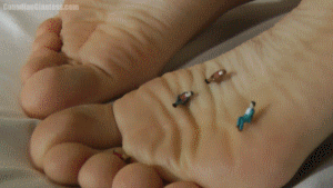 Eve is laying in bed, unaware of the tiny people upon her sole. This one has a lot of longer scenes of her feet since Eve took her time rolling around her unaware intruders under her big toes. A few are also tossed around by her unaware fingers who were in her palm. They're finally squished when she closes her fist around them and remains resting. Finally she notices a group of the micro people on her other foot and sits up, realizing they are tiny people. Eve just steps on them, annoyed to see more of them, and goes back to rest. 7min 54sec.
