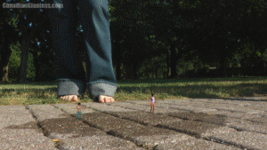 This is definitely a lot different for us. Introducing Lily Mayflower an all new model who comes across two shrunken women who are stuck in some sort of liquid in a park. Thinking that it's rather harmless, Lily stomps both girls under her bare feet only to realize that the substance she's stepped into is strong enough to get her stuck as well! She pulls on her legs and struggles but just can't get free. Finally she notices a sign that says 'Permanent Glue Trap' on the archway she's standing under. Lily growls in frusteration but no matter what she does it's no use. She's permanently stuck. The first minute involves the squish scene with the two stuck girls and the rest of the video focuses on Lily Mayflower herself being stuck.
